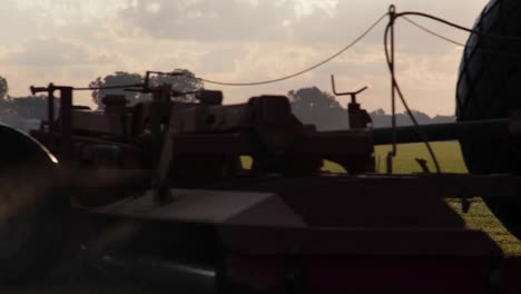 Large-farming-equipment-close-up-drive-by-early-morning-sunrise-on-commercial-farm