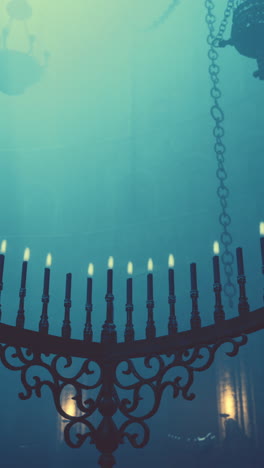 a vintage chandelier with candles in a dark church