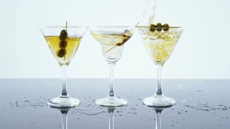 Yellow-drink-being-poured-into-three-glasses-of-cocktail