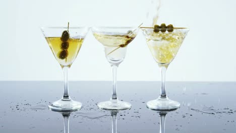 yellow drink being poured into three glasses of cocktail