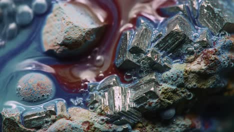 captivating close-up of metallic crystals surrounded by vivid colorful liquid with bubbles, showcasing natural beauty and intricate details of mineral formation