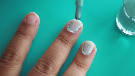 woman applying light blue nail polish