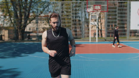 athletic sport man jogger use smart watch checking heart rate route for running on basketball court
