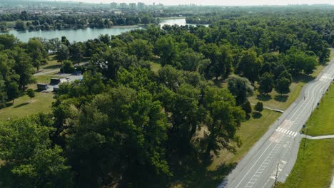 aerial view of bike path beside lake jarun with forest and city in background