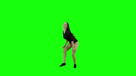 happy young woman is dancing and smiling in front of a green screen