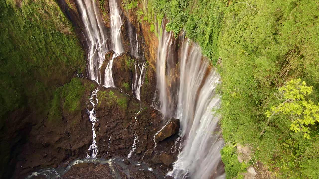 la cascada tumpak sewu, la majestuosa cascada que se sumerge sobre exuberantes acantilados, ofrece una vista impresionante con sus múltiples arroyos que fluyen como una cortina de niebla