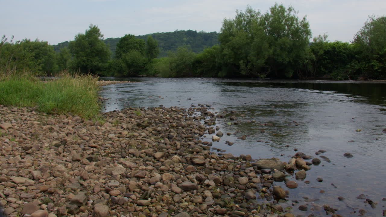Ampia inquadratura che risale il fiume Lune con una riva rocciosa, a Brookhouse.
