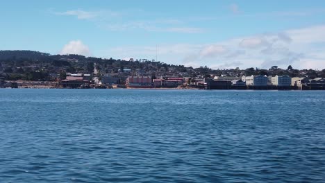 Kardanischer-Weitschuss,-Der-Von-Einem-Boot-Auf-Dem-Ozean-Vor-Der-Küste-Von-Monterey,-Kalifornien,-An-Einer-Konservenfabrik-Vorbeifährt