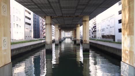 el agua tranquila fluye debajo de un puente de la ciudad.