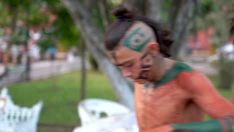 primer plano extremo de una bailarina maya o azteca tocando una concha durante una danza sagrada