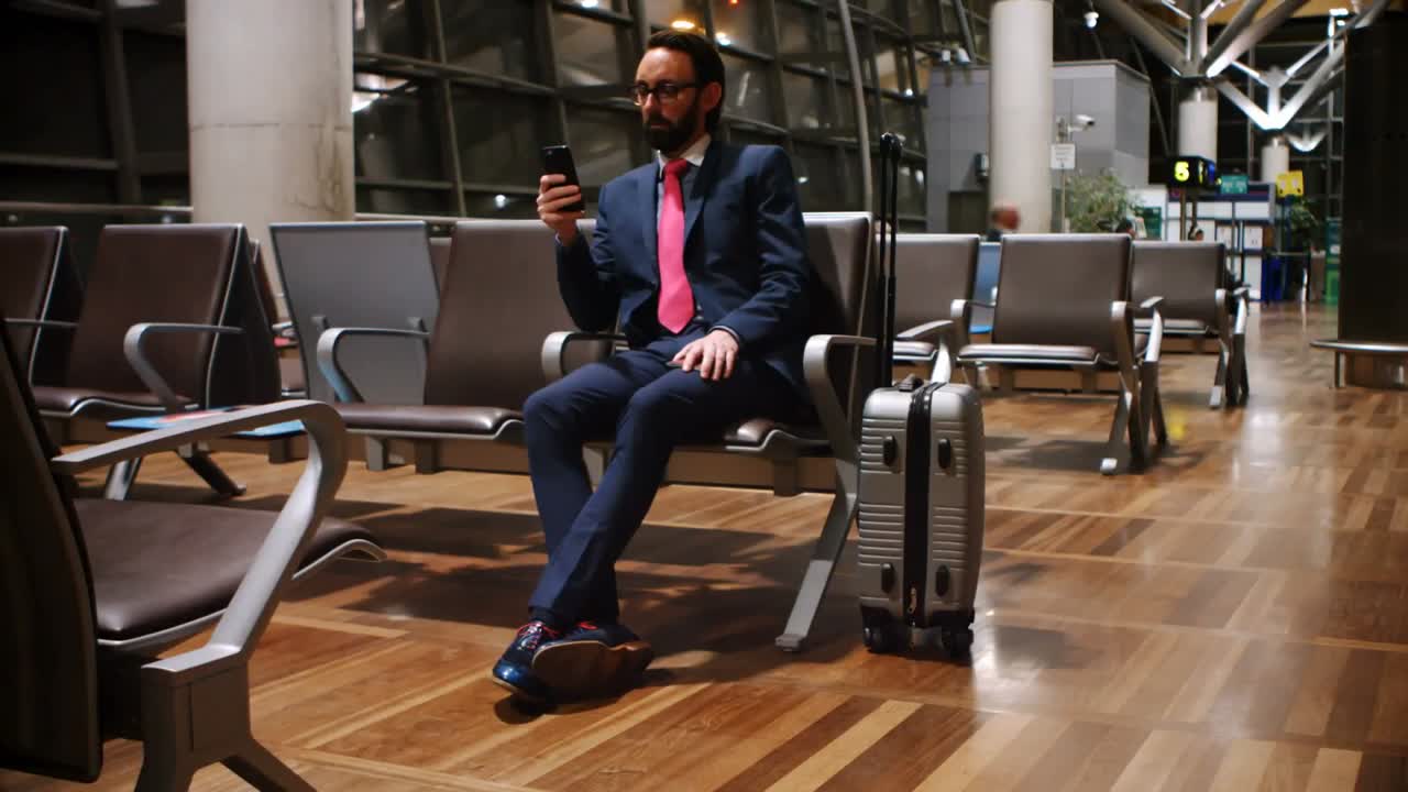 Pendolare che usa il telefono cellulare in sala d'attesa 4k