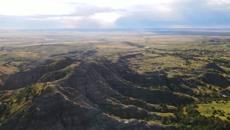 Vista-Aérea-De-Seguimiento-De-Una-Gran-Colina-Con-Capas-De-Estrato-Muy-Claras-De-Rocas-Variadas-En-El-Este-De-Wyoming-Durante-El-Verano