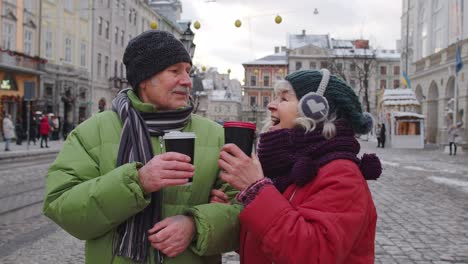 una pareja de ancianos turistas abuela abuelo viajando, bebiendo té caliente en el centro de la ciudad