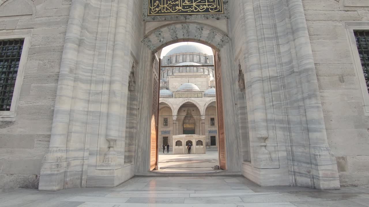 vista en primera persona caminando a través del portal de entrada hacia el patio de la mezquita süleymaniye, estambul en turquía. fpv
