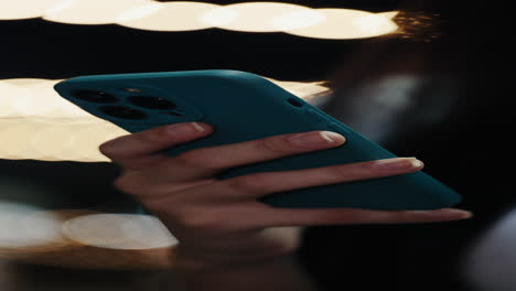 woman using teal smartphone at night