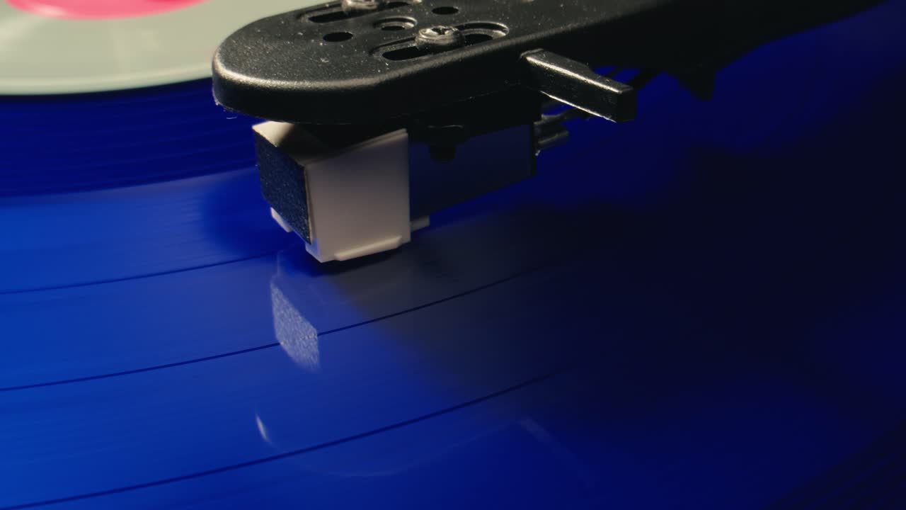 Närbild av skivspelarnål som spelar blå vinylskiva