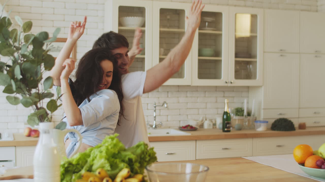 jóvenes amantes bailando y divirtiéndose en casa