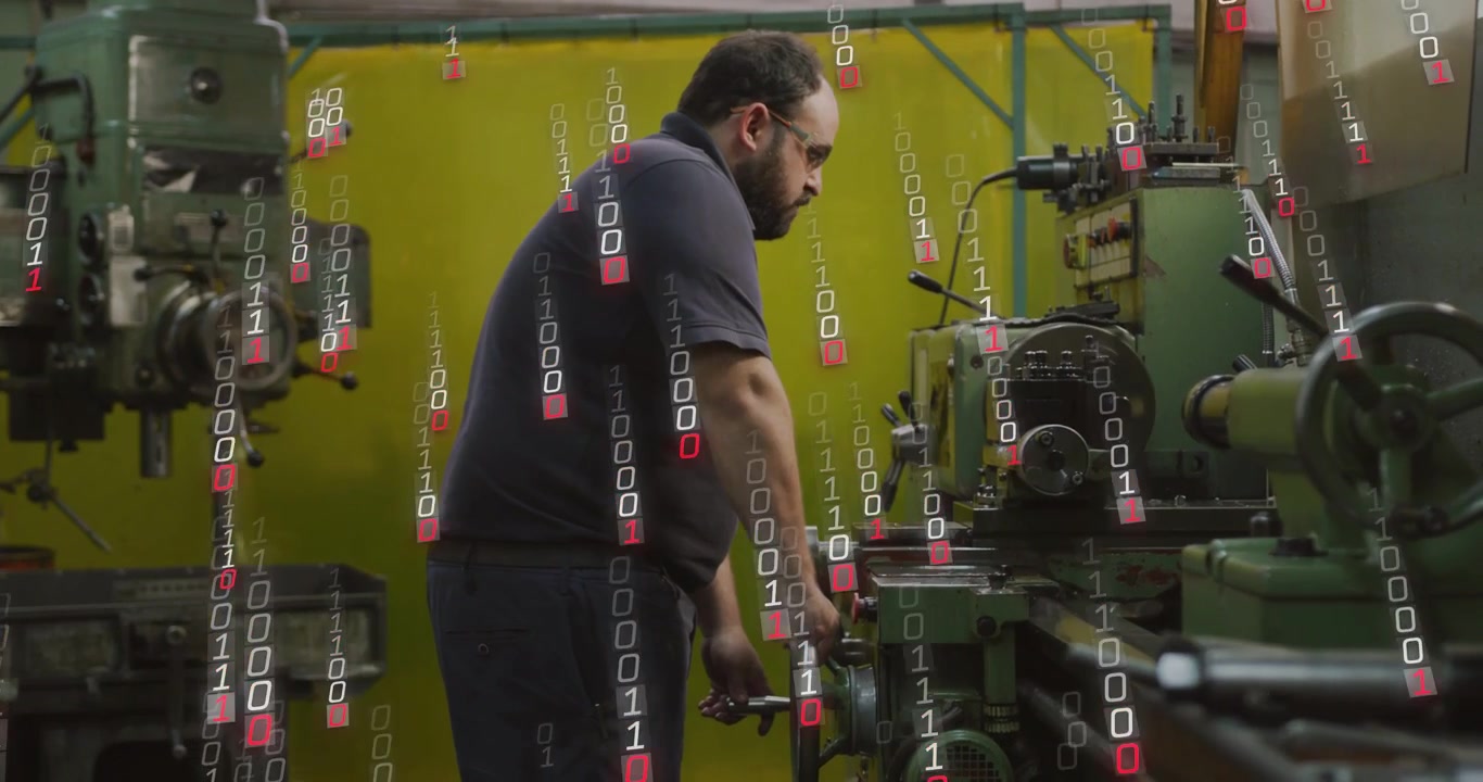 Machinist turning lathe wheel, inspecting workpiece while falling binary overlay showing production