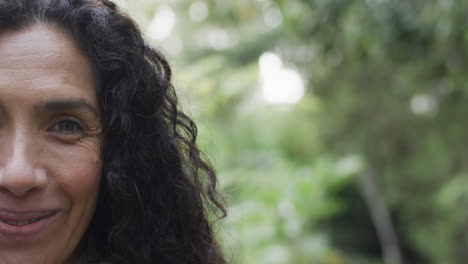 Half-portrait-of-happy-biracial-woman-in-sunny-garden-with-copy-space,-slow-motion