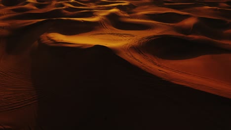 Aerial-view-of-4x4-off-road-land-vehicle-taking-tourists-on-desert-dune-bashing-safari-in-Dubai,-UAE