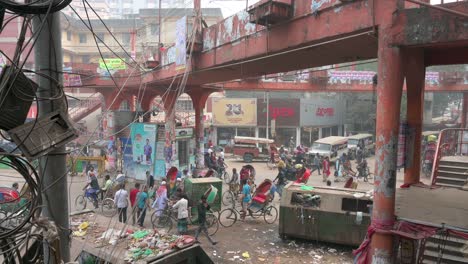 daily life scene of a busy road showcasing numerous vehicles such as cars, motorcycles, and rickshaws as well as pedestrians and a pedestrian bridge in dhaka, bangladesh