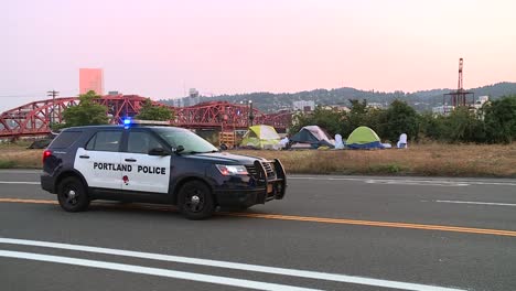 coche de policía de la policía de portland en un campamento para personas sin hogar