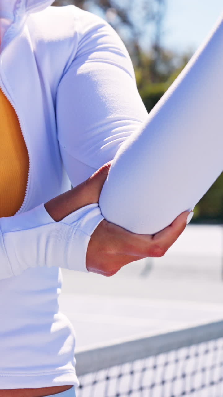 Woman Stretching Arm and Elbow on a Sunny Tennis Court
