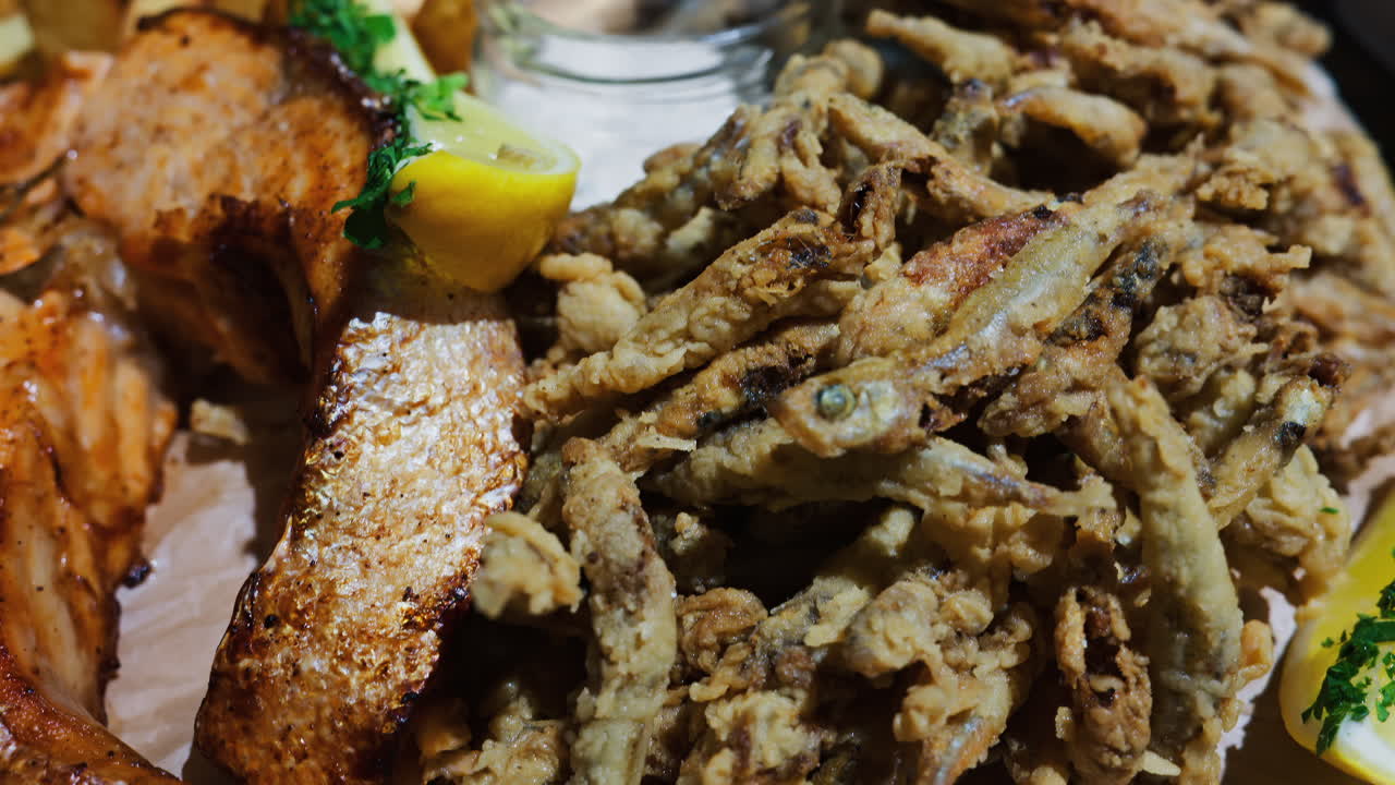 Primo piano di un piatto di fritto misto con salmone e patate al ristorante