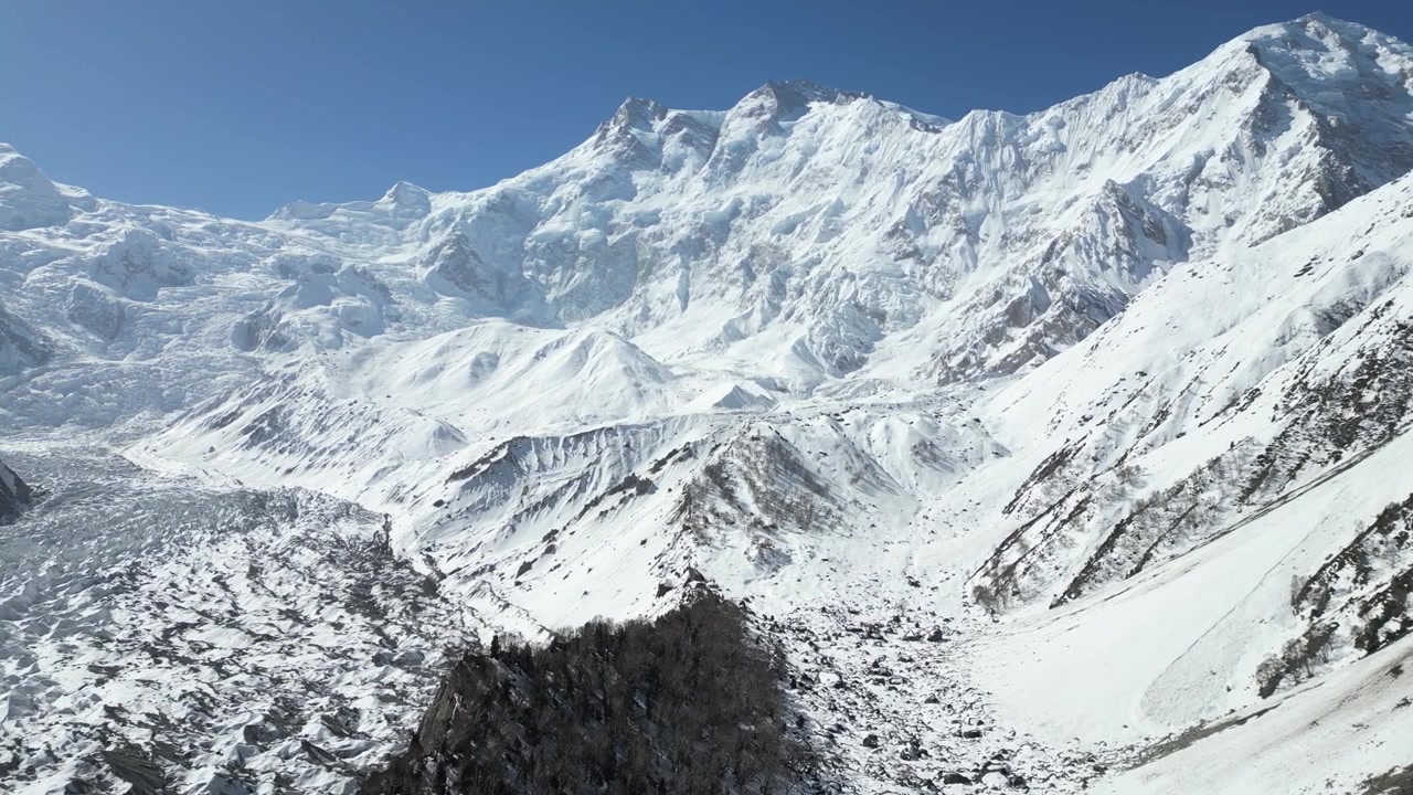 Ripresa aerea con drone di aspre cime montuose innevate e una valle glaciale vicino al campo base di Fairy Meadows nella Valle di Hunza, Pakistan. Geografia alpina spettacolare