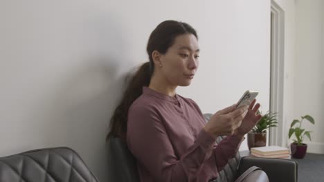 Candidatos-Masculinos-Y-Femeninos-En-El-Cargo-Esperando-Una-Entrevista-De-Trabajo-Mirando-El-Teléfono-Móvil-Y-Leyendo-Notas