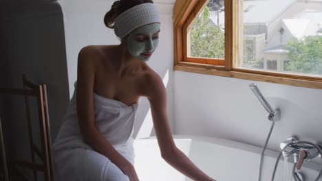 woman sitting on edge of bathtub in bathroom