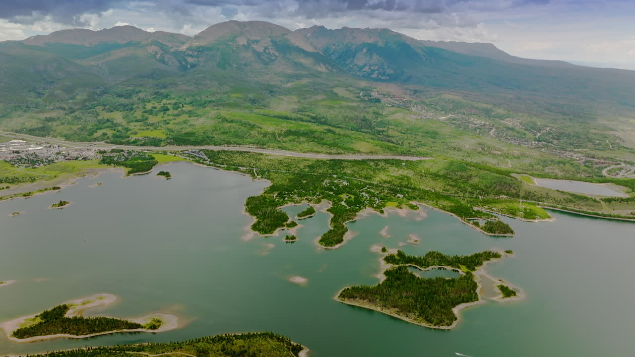 Beautiful scenery of river with little green islands in it. Gorgeous mountains of Colorado state. Aerial perspective.