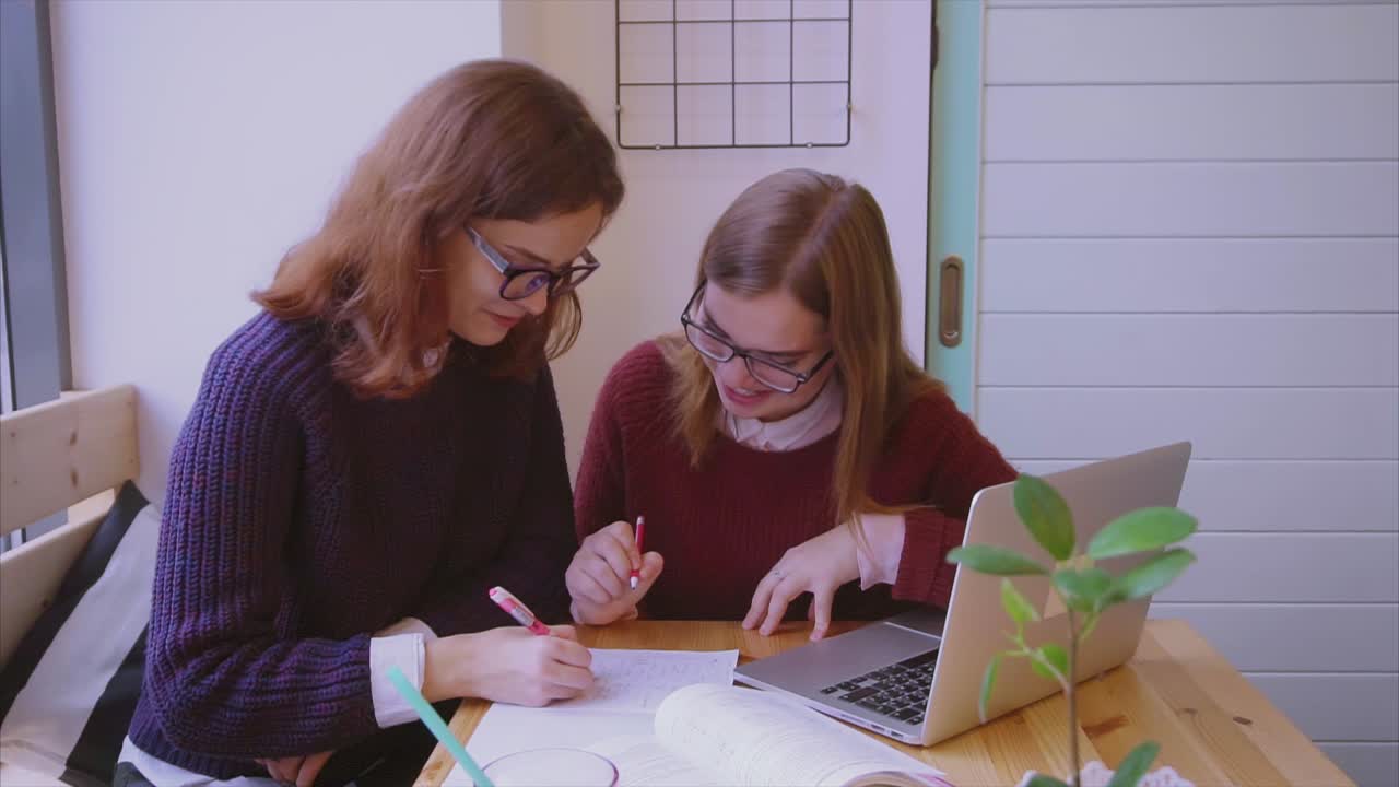 dos estudiantes estudiando juntos en un café