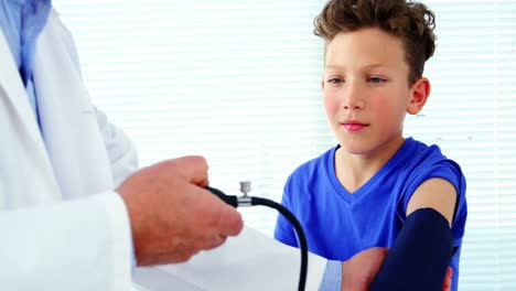 male doctor checking blood pressure of patient