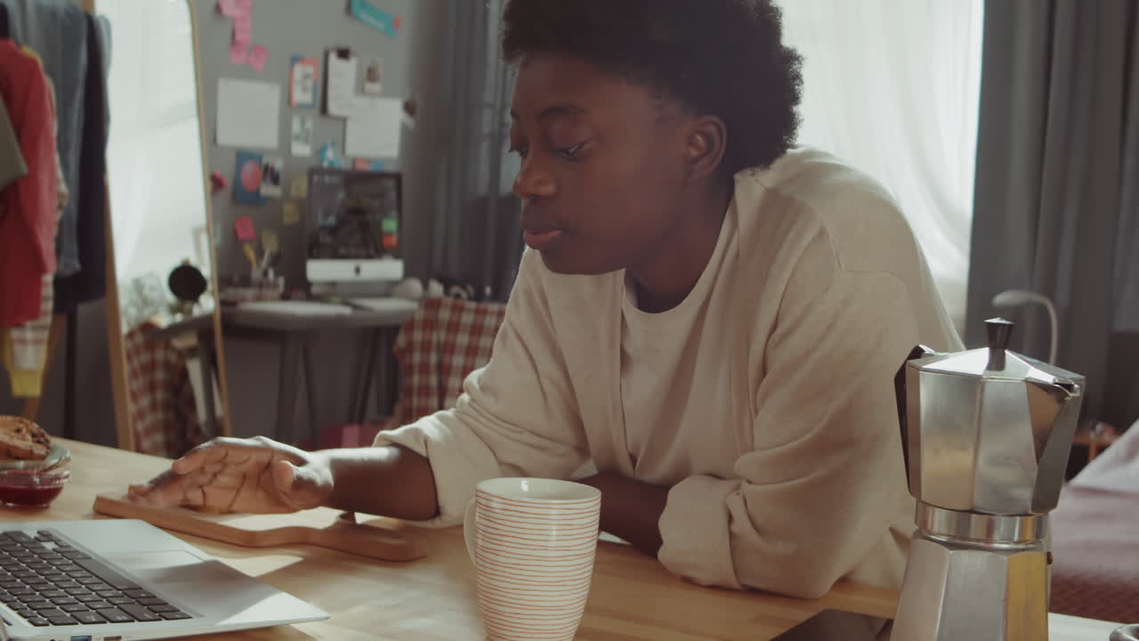Donna Nera che Beve Caffè e Usa il Laptop a Casa