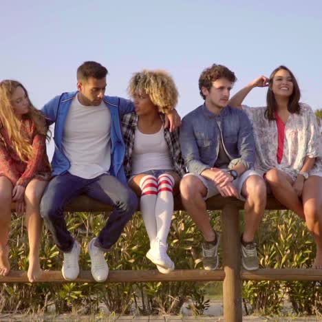 young people sitting on wooden fence