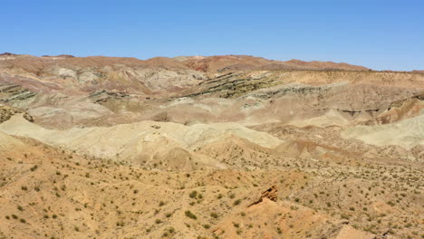 slow pullback view of the layers of earth and different colours of the rainbow basin the mojave desert