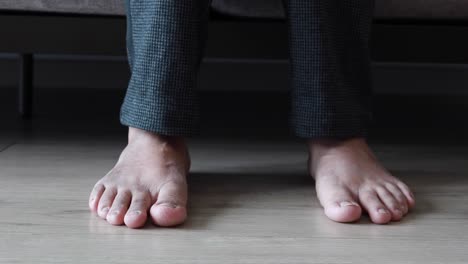 young women feet on wooden floor sitting on sofa