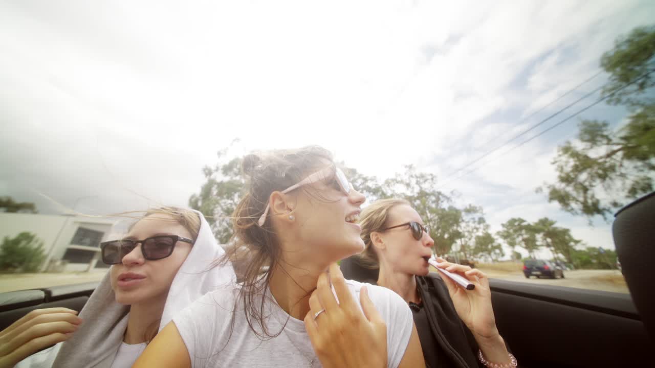 Friends enjoying a convertible road trip