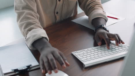 Young-African-American-Businessman-Working-on-Computer-and-Taking-Notes