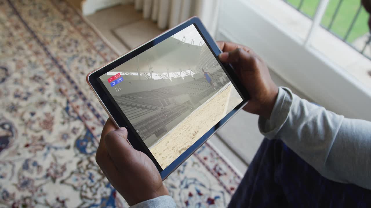 compuesto de un hombre sentado en casa, viendo el evento de salto de longitud de atletismo en la tableta