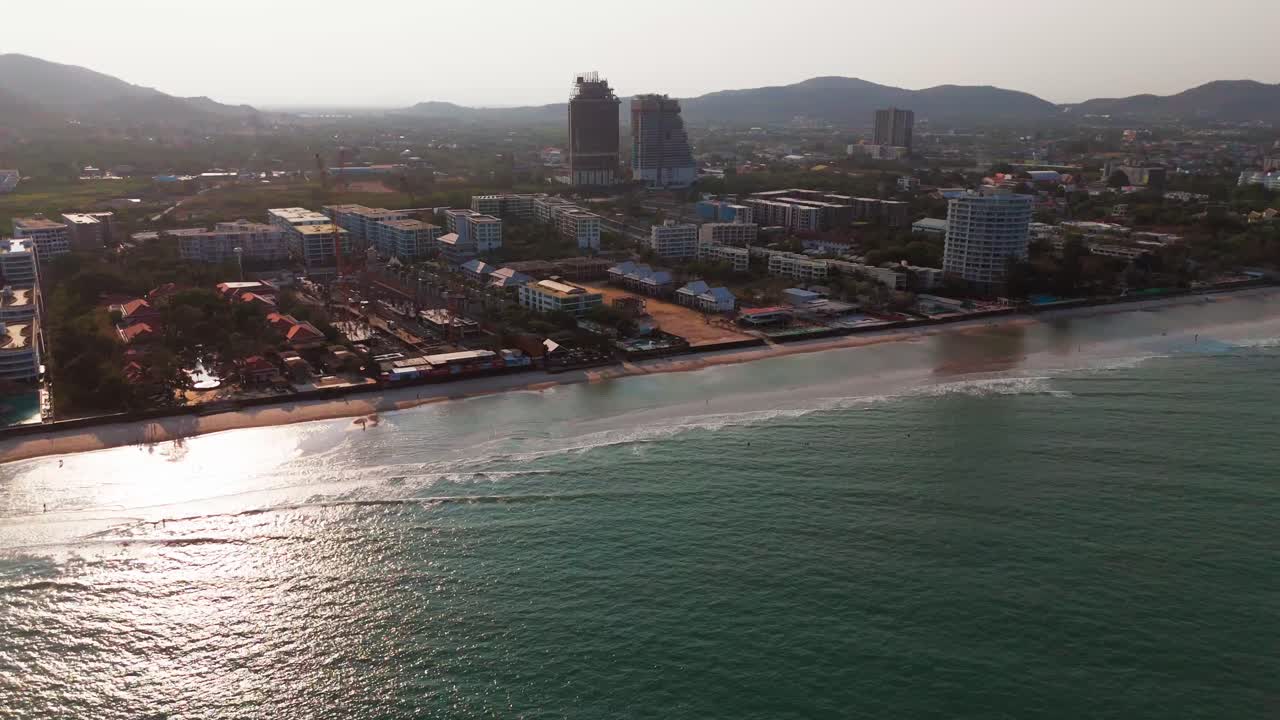 Sunset aerial view of Hua Hin beach drone fly above waterfront hotel building on tropical ocean sea travel holiday destination near Bangkok