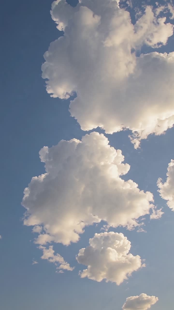 Sebuah video yang tenang merekam awan berbulu dengan latar langit biru cerah, diambil dari sudut rendah.