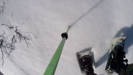 Una-Cámara-De-Acción-Filmada-De-Un-Excursionista-De-Invierno-Usando-Raquetas-De-Nieve-Escalando-Una-Montaña-Con-Un-Bastón-De-Trekking-En-La-Isla-De-Kodiak,-Alaska