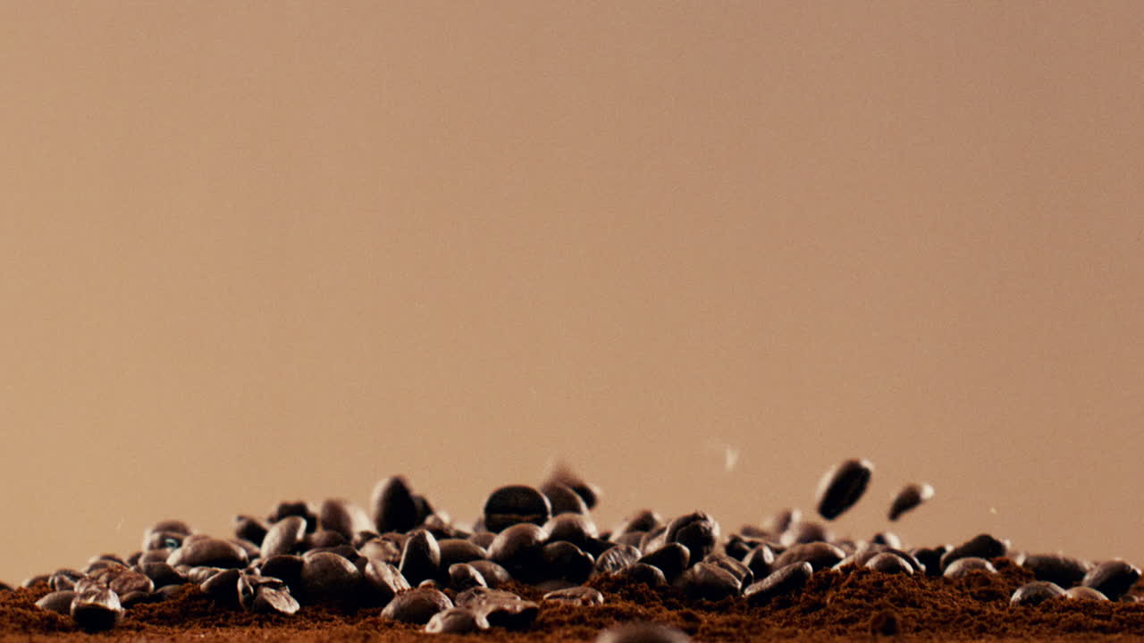 Coffee beans falling onto ground coffee