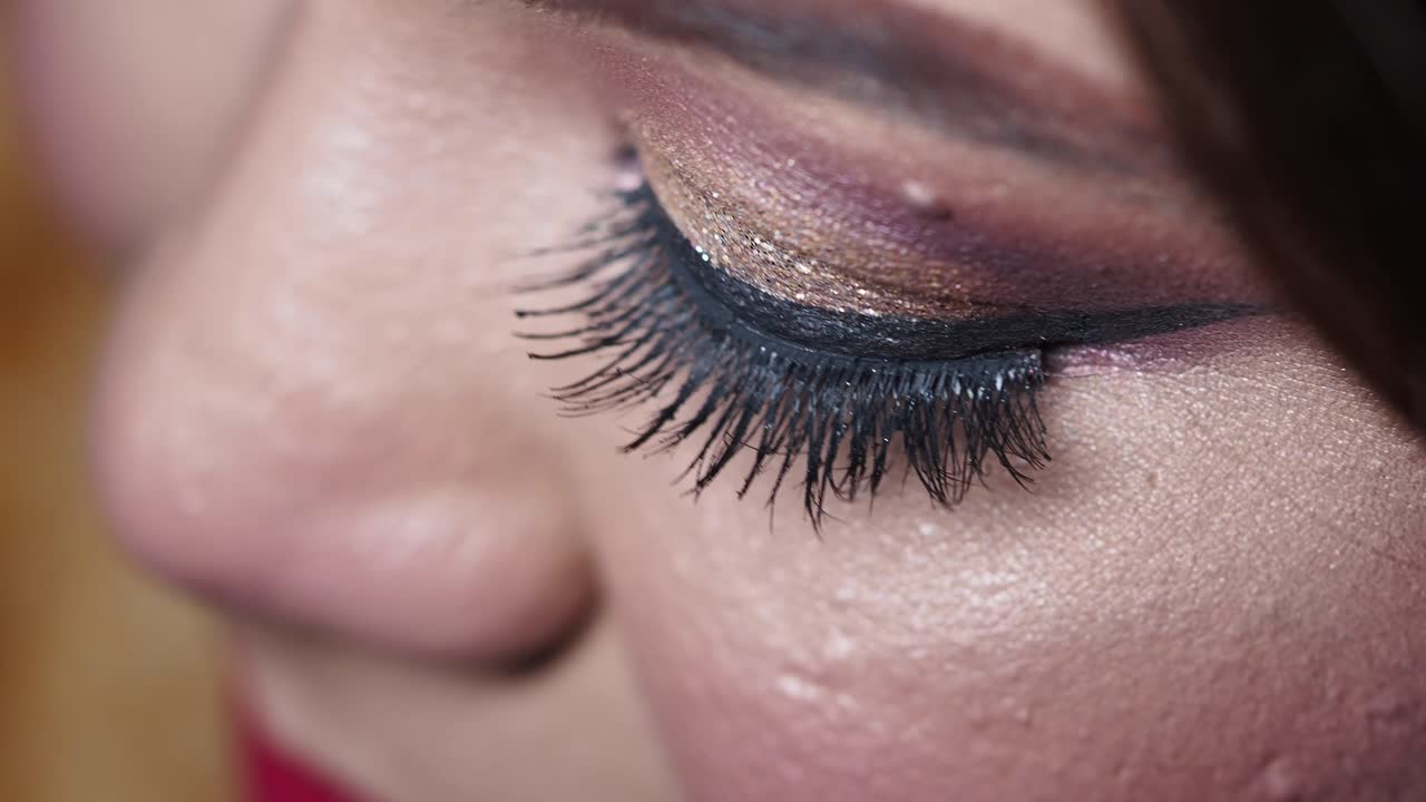 Close-up of a glamorous eye with elaborate makeup and glitter eyeshadow