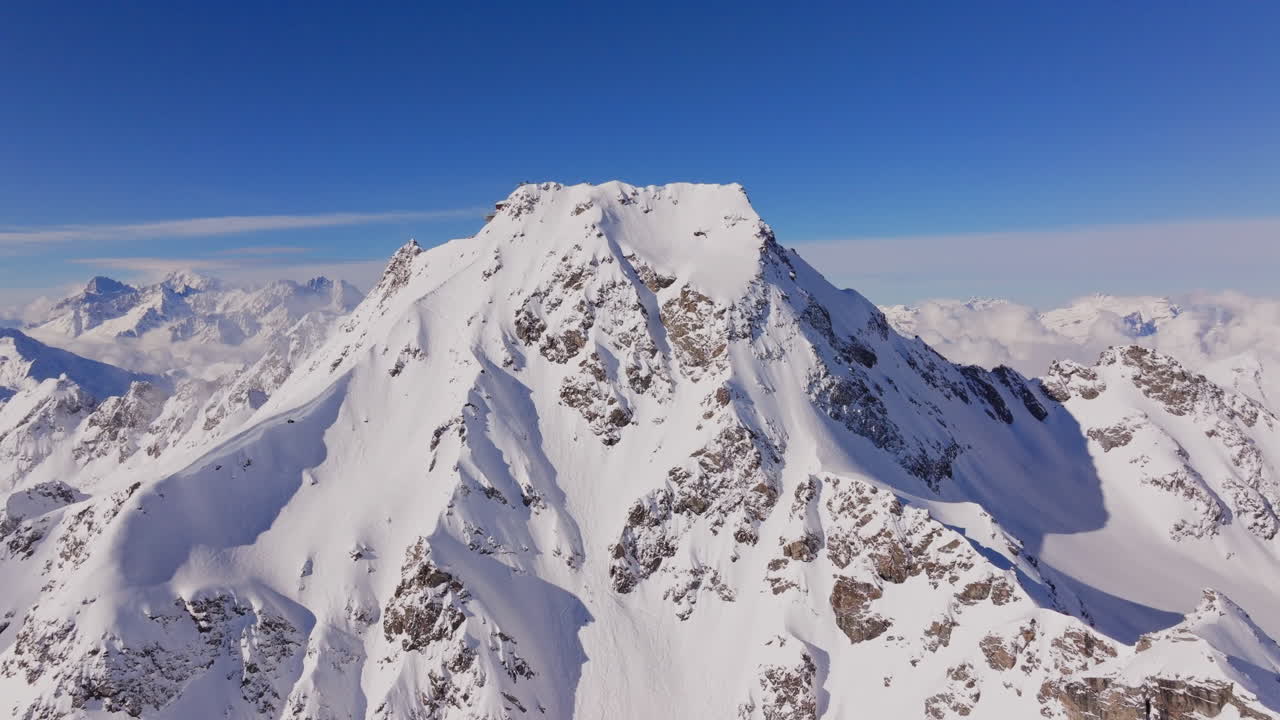 Aerial footage of the iconic freeride paradise of Verbier on a stunning bluebird day. Snow-covered peaks, wide open faces, and legendary off-piste terrain under clear alpine skies