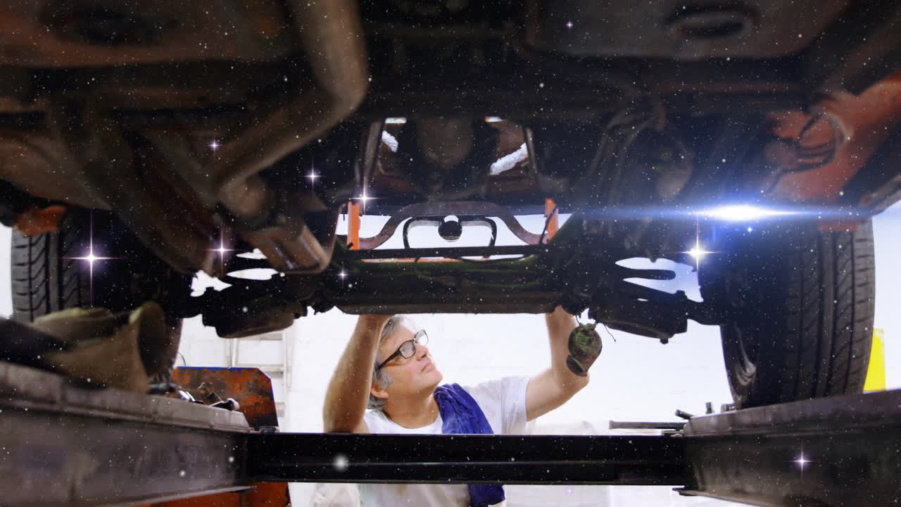 Automotive mechanic inspecting vehicle undercarriage in workshop, showing animated wrench icons