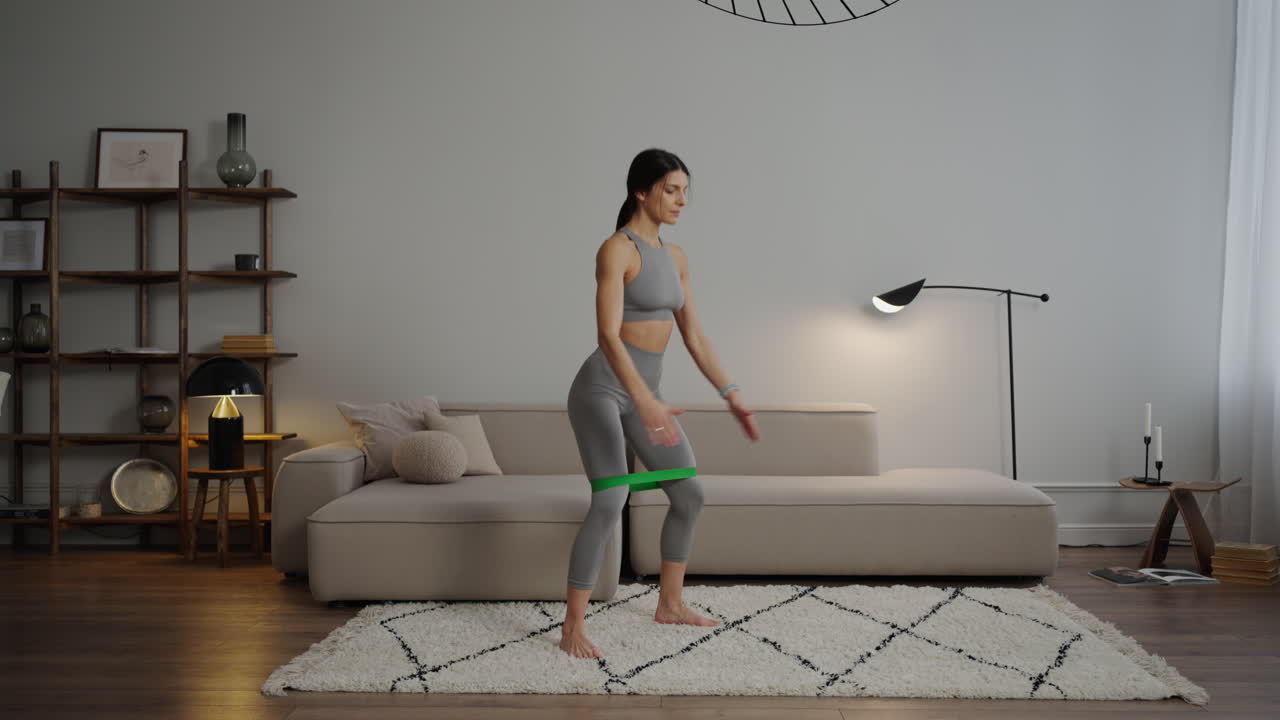 mujer haciendo ejercicios para las piernas con banda de resistencia en casa