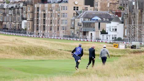 golfers walking on a green field